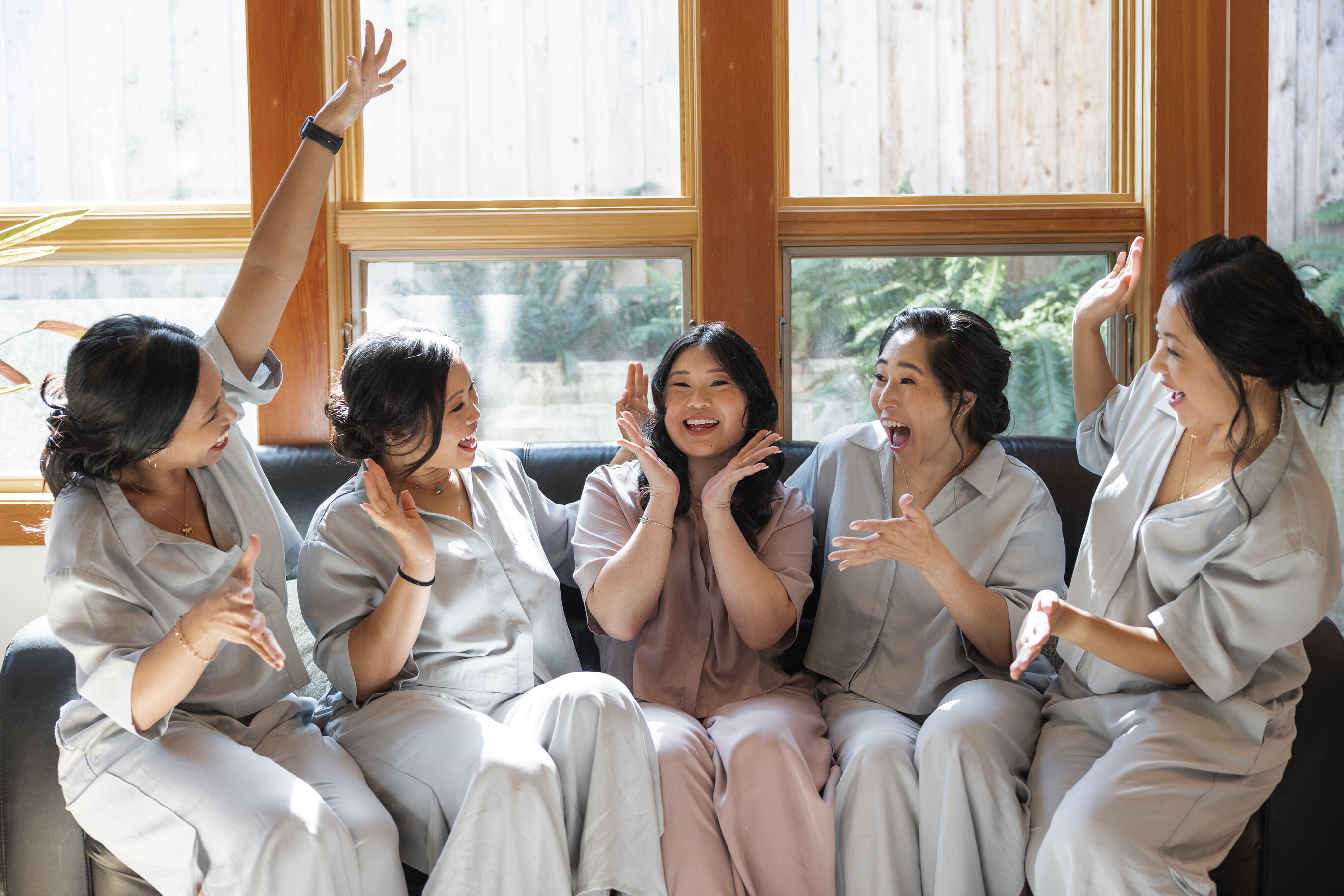 Bridal party photo featuring a bride in white gown surrounded by bridesmaids in warm-toned dresses