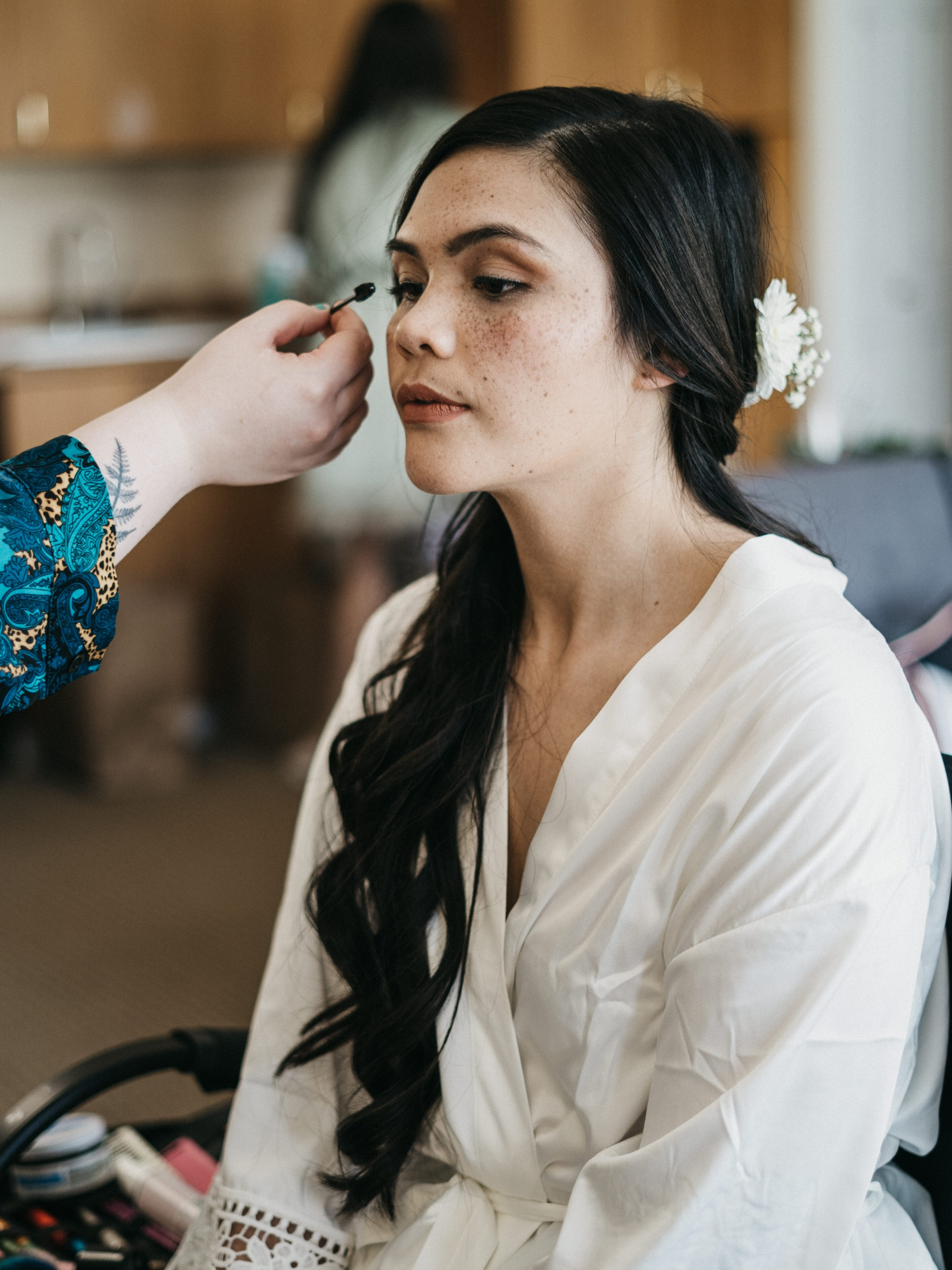 A Blushing Flower Events professional makeup artist working with a Bride during her wedding day preparations